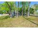 Quaint gray home nestled among mature trees on a well-maintained lawn in a quiet neighborhood at 2601 Dora Dr, Charlotte, NC 28215