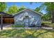 Charming gray brick home with lush green lawn and covered parking area at 2601 Dora Dr, Charlotte, NC 28215