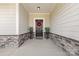 Inviting front porch features stone accents, a stylish front door with a wreath, and decorative potted plants at 2704 Watergarden St, York, SC 29745