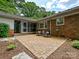 Charming backyard patio with brick accents, comfortable seating, and views of the lush landscape at 301 Glen Oaks Rd, Charlotte, NC 28270
