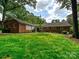 Spacious backyard featuring a well-maintained lawn and a classic brick home exterior at 301 Glen Oaks Rd, Charlotte, NC 28270