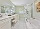Luxurious bathroom featuring a soaking tub, glass shower, and double vanity sinks at 301 Glen Oaks Rd, Charlotte, NC 28270