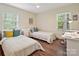 Bright bedroom with hardwood floors, two twin beds, and natural light from two windows at 301 Glen Oaks Rd, Charlotte, NC 28270
