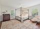 Bedroom with a canopy bed, area rug, a chest of drawers and large windows at 301 Glen Oaks Rd, Charlotte, NC 28270