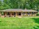 Charming brick home featuring a spacious front yard and inviting covered porch at 301 Glen Oaks Rd, Charlotte, NC 28270