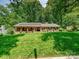 Beautiful brick home with solar panels and a sprawling green lawn, surrounded by mature trees at 301 Glen Oaks Rd, Charlotte, NC 28270