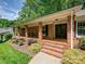 Inviting brick front porch featuring ample seating and landscaping at 301 Glen Oaks Rd, Charlotte, NC 28270