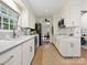Galley kitchen features white cabinets, stainless steel appliances, and a cozy adjacent dining area at 301 Glen Oaks Rd, Charlotte, NC 28270