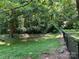 Fenced backyard featuring lush greenery, mature trees, and a tranquil outdoor space at 33611 Mann Rd, Albemarle, NC 28001
