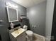 Neutral bathroom with a standard toilet, sink, mirror, and shelving to store bathroom essentials at 33611 Mann Rd, Albemarle, NC 28001