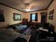 Bedroom with a bed, lounge furniture, ceiling fan, natural light, neutral walls, and game console at 33611 Mann Rd, Albemarle, NC 28001