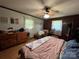 Bedroom featuring hardwood floors, natural light, ceiling fan, and wood paneled accent wall at 33611 Mann Rd, Albemarle, NC 28001