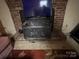 This house features a brick fireplace with a black metal wood stove, adding character to the space at 33611 Mann Rd, Albemarle, NC 28001