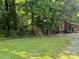 Well-maintained front yard with green grass and mature trees surrounding the house, creating a serene setting at 33611 Mann Rd, Albemarle, NC 28001