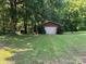Detached two car garage with white door and brown trim surrounded by a grassy yard at 33611 Mann Rd, Albemarle, NC 28001