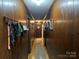Hallway with wood paneled walls, wood floors and coat rack with an area rug at 33611 Mann Rd, Albemarle, NC 28001