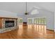 Spacious living room featuring a stone fireplace, hardwood floors, and views of the lake at 376 Oak Tree Rd # 37, Mooresville, NC 28117
