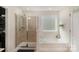 Well-lit bathroom featuring a glass-door shower, soaking tub, and a decorative window for a luxurious feel at 3912 Franklin Meadows Dr, Matthews, NC 28105
