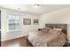 Cozy bedroom featuring hardwood floors, a comfortable bed, and natural light from the window at 3912 Franklin Meadows Dr, Matthews, NC 28105