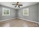 Well-lit bedroom featuring plank flooring, neutral color scheme, and two windows at 500 Dedmon Dr, Charlotte, NC 28216