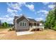 Home exterior featuring a covered back porch, a neatly maintained lawn, and patio at 5162 Beckenham Ln, Concord, NC 28025