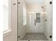 Modern bathroom features a glass shower with elegant marble tiling and dark fixtures at 5162 Beckenham Ln, Concord, NC 28025