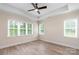 Light-filled bedroom with hardwood floors, a ceiling fan, and bright windows at 5162 Beckenham Ln, Concord, NC 28025