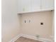White laundry room features cabinets and connections for laundry machines at 5162 Beckenham Ln, Concord, NC 28025