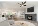 Open-concept living space with stone fireplace, modern ceiling fan and view of a spacious kitchen and dining area at 5162 Beckenham Ln, Concord, NC 28025