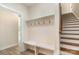 A mudroom has a convenient bench with hooks and stairs with a wooden rail at 5162 Beckenham Ln, Concord, NC 28025