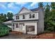Two-story home featuring gray siding, black roof, open garage, and charming curb appeal against a blue sky backdrop at 530 Gantt St, Mooresville, NC 28115