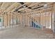 Unfinished living room showing the bare stud framework and staircase to the upper level at 530 Gantt St, Mooresville, NC 28115