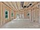 This unfinished living room features exposed framework, rough flooring, and window openings at 530 Gantt St, Mooresville, NC 28115
