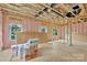 Unfinished living room featuring exposed framing, pink insulation, and exterior view windows at 530 Gantt St, Mooresville, NC 28115