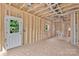 Exposed stud framework of the room with wiring, piping, a door, and a large window at 530 Gantt St, Mooresville, NC 28115