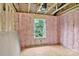 Unfinished room featuring exposed framing, pink insulation, and window view at 530 Gantt St, Mooresville, NC 28115