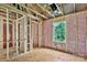 Unfinished room featuring exposed framing, pink insulation, and an exterior view window at 530 Gantt St, Mooresville, NC 28115