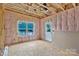 Interior of an unfinished room showing studs, insulation, plywood subfloor, window and exterior door at 530 Gantt St, Mooresville, NC 28115