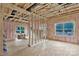 Unfinished room showing interior framing, pink insulation, OSB subfloor and window views to the exterior at 530 Gantt St, Mooresville, NC 28115