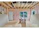 Unfinished room with exposed framing, pink insulation, OSB subfloor, and a view to the outside at 530 Gantt St, Mooresville, NC 28115