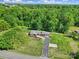 Aerial view of a beautiful brick home featuring a long driveway, attached garage, and surrounded by lush trees at 5938 Mundy Rd, Denver, NC 28037