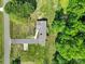 Aerial view of a brick home with a long driveway, landscaped yard, and surrounded by lush greenery, offering a serene setting at 5938 Mundy Rd, Denver, NC 28037