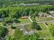Expansive aerial view showing a rural property including the home, outbuildings, landscaping and a forest at 5938 Mundy Rd, Denver, NC 28037