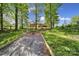 Expansive backyard featuring a brick patio, Adirondack chairs, and verdant lawn with mature trees, perfect for outdoor enjoyment at 5938 Mundy Rd, Denver, NC 28037