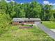 Well-maintained brick home featuring a manicured lawn, mature trees, and an attached garage, showcasing curb appeal at 5938 Mundy Rd, Denver, NC 28037