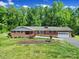 Charming one-story brick home featuring a well-manicured lawn, attached garage, and inviting front porch at 5938 Mundy Rd, Denver, NC 28037