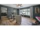 Inviting living room with dark walls, large windows, plush armchairs, and an array of plants at 5938 Mundy Rd, Denver, NC 28037