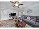 Spacious living room featuring a comfortable gray sofa, TV, wood-look flooring, and natural light at 5938 Mundy Rd, Denver, NC 28037