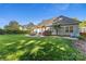 A landscaped backyard featuring a wooden pergola, a fire pit, and a lush lawn at 6002 Sentinel Dr, Indian Trail, NC 28079
