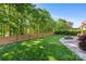 A landscaped backyard with a wooden fence, fire pit, and lush lawn at 6002 Sentinel Dr, Indian Trail, NC 28079